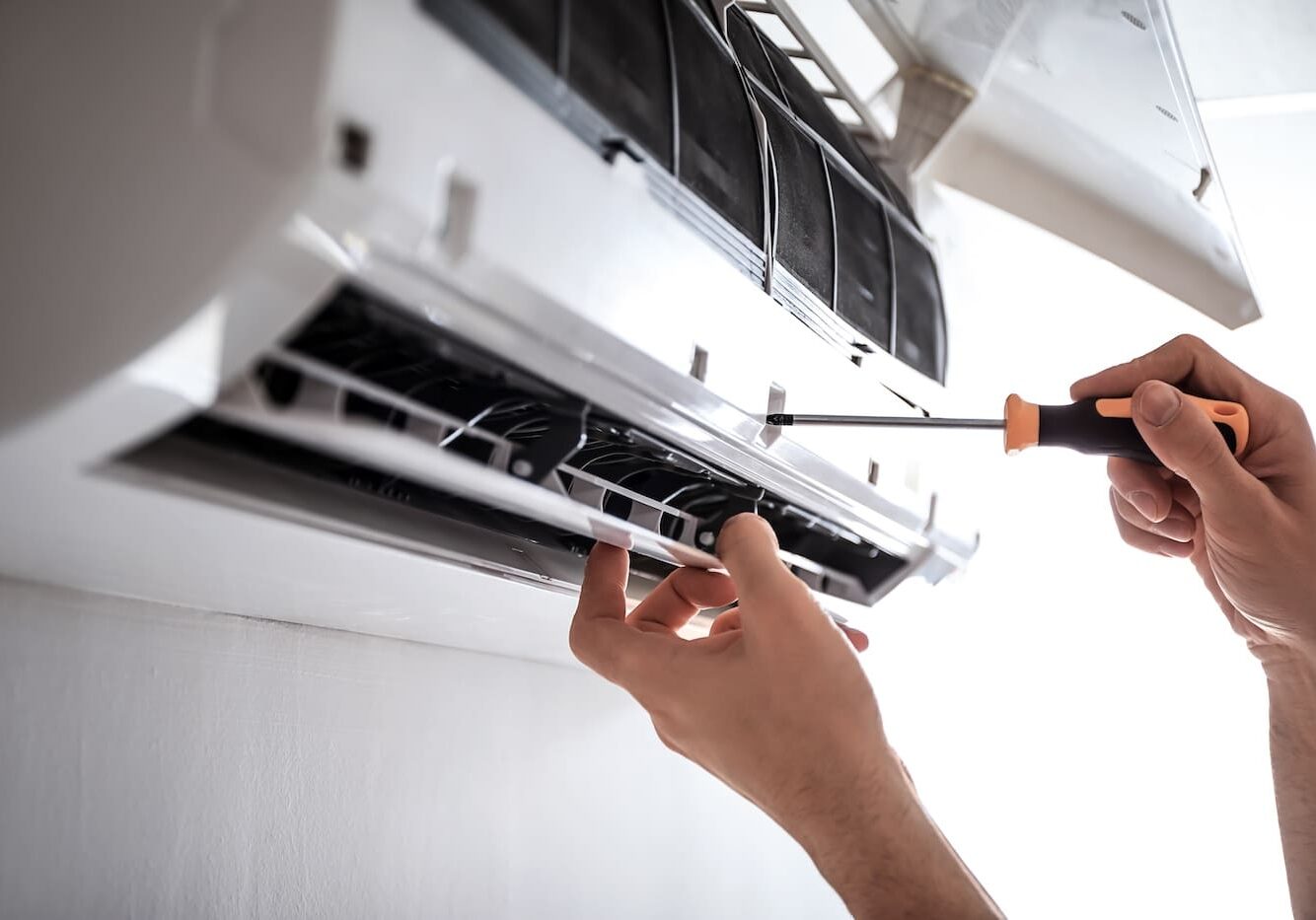 Electrician repairing air conditioner indoors